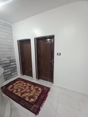 a room with two doors and a rug on the floor at Jamaica Guest House in Aswan