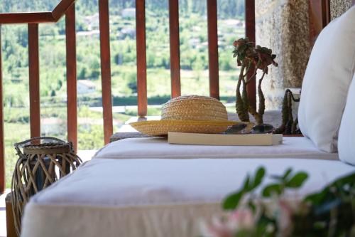 a bed with a straw hat on top of it at Leiras do Seixo - Casa dos Tinos in Amarante