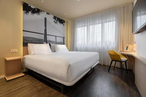 リスボンにあるIkonik Lisboaの窓付きの客室で、白い大型ベッド1台が備わります。