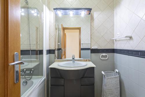 a bathroom with a sink and a shower and a mirror at Real Alegria - Terrace with pool - Vilamoura in Vilamoura