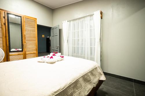 - une chambre avec un lit doté de draps blancs et une fenêtre dans l'établissement Casa Luz, à San Isidro de El General