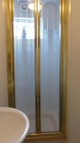 um chuveiro com uma porta de vidro ao lado de um lavatório em Relax in a 1 Bedroom Apartment near a country Pub em Eyemouth