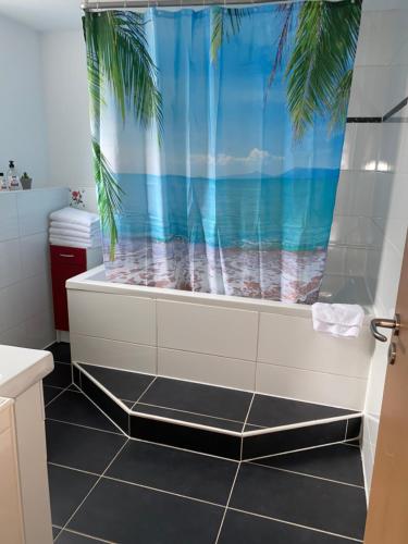 a bathroom with a bath tub with a view of the ocean at Apartment Stabel 8,1 km von Europa Park in Kippenheim