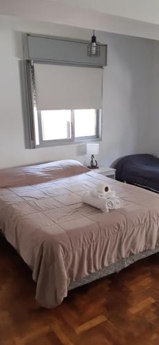 un dormitorio con una cama con un animal de peluche en Greta Apartment I en Mendoza