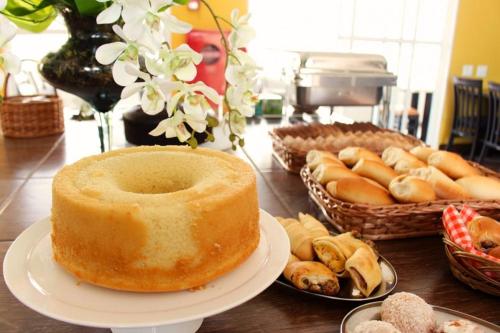 a table with a large cake and baskets of bread at Don Marcos Hotel com Restaurante e Pizzaria in Guarujá
