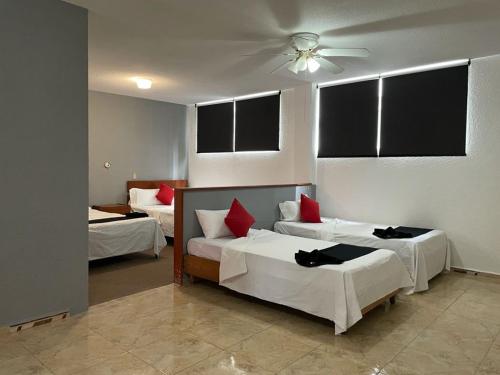 um quarto com 2 camas e uma ventoinha de tecto em HOTEL SiCILIA iTALIA em Aguascalientes