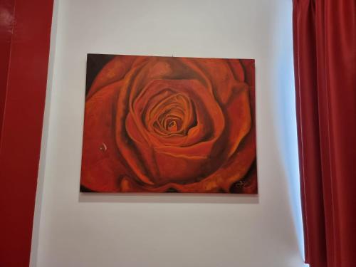 a painting of a red rose on a wall at BARBAJA SUITES IN STREET TOLEDO 205 in Naples