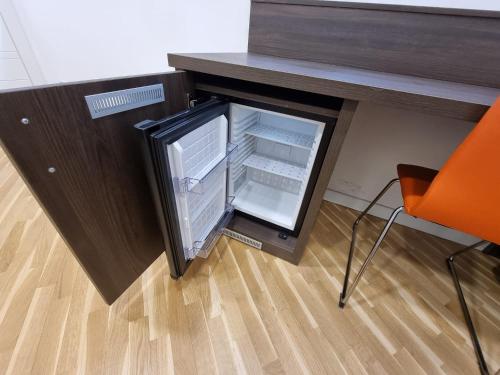 an open refrigerator sitting under a desk with a chair at BARBAJA SUITES IN STREET TOLEDO 205 in Naples