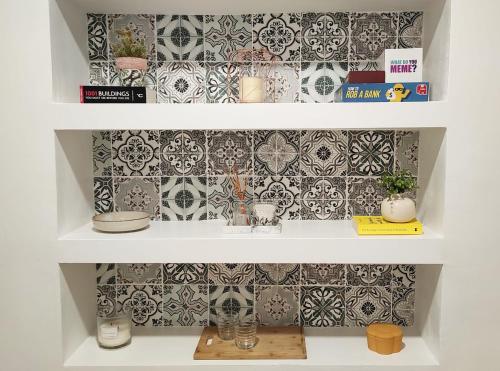 a white shelf with a wall with tiles at Almirante24 - Apartment with Garden - Ajuda Palace & Royal Treasure Museum in Lisbon