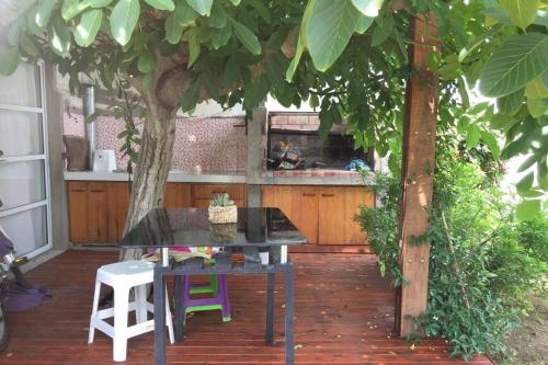 a table and chairs on a patio under a tree at Departamento frente al mar in Santa Teresita