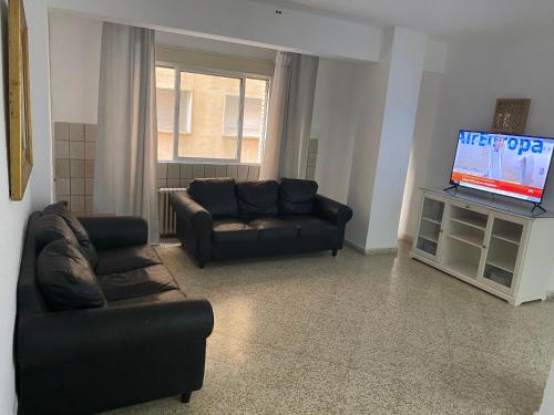a living room with a couch and a tv at Pensión Eurosol in Granada