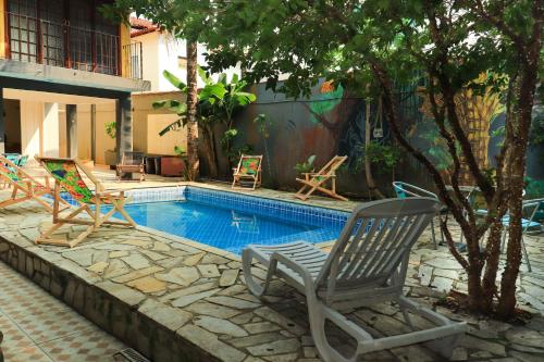 uma piscina com cadeiras e uma mesa em Hostel Morada do sol Paraty em Paraty