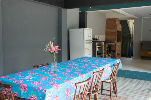 a table with a blue table cloth with a vase of flowers on it at Hostel Morada do sol Paraty in Paraty