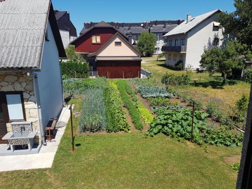 un jardín al aire libre con verduras y una casa en Apartment Milka, en Korenica