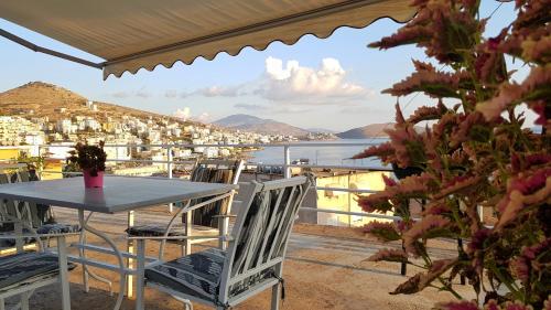 a table and chairs on a balcony with a view of the water at Joen Apartments in Sarandë