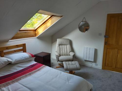 a bedroom with a bed and a chair and a window at Kirkhouse in Wick
