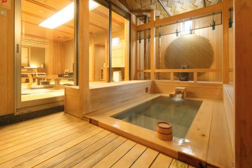 a jacuzzi tub in the middle of a room at Bettei Soan in Minami Aso