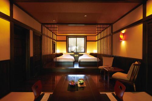 a hotel room with two beds and a table at Bettei Soan in Minami Aso