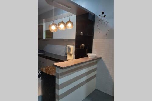 a kitchen with a counter and some lights at Homestay Dferry Jerantut Fully Aircond in Jerantut
