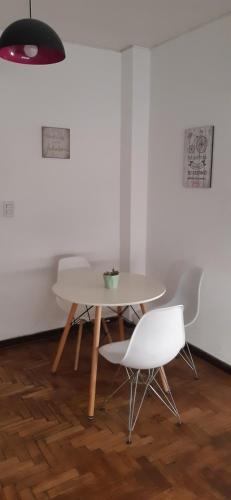 una mesa con 2 sillas y una mesa y sillas blancas en Greta Apartment I en Mendoza