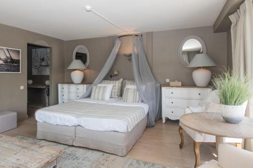 a bedroom with a bed and a table and mirror at Lebeaubylivingroom Hotel in Knokke-Heist
