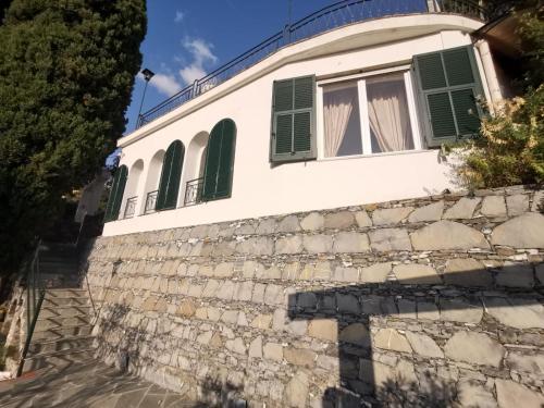 拉帕洛的住宿－Rapallo Summer House，石墙上带有绿色百叶窗的建筑