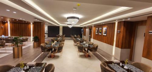 a restaurant with tables and chairs in a room at Lilac Hotel - Amman in Amman