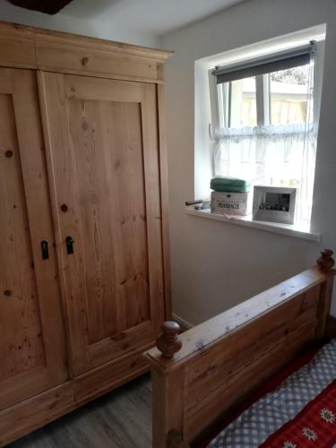 a bedroom with a wooden door and a window at Ochsenhof in Feuchtwangen