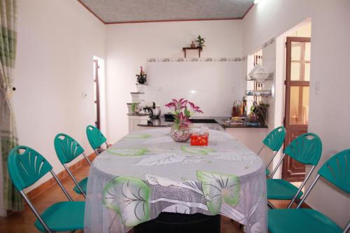 a dining room with a table and green chairs at Sac Xanh Homestay in Hoi An