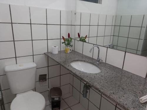 uma casa de banho com um WC branco e um lavatório. em Solaris Sul em Teresina