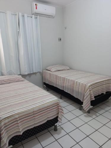 dos camas sentadas una al lado de la otra en una habitación en Solaris Sul en Teresina