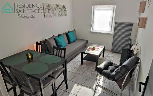 un salon avec une table et un canapé dans l'établissement Résidence Sainte Cécile, à Thionville