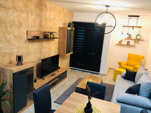 uma sala de estar com um sofá e uma televisão em Masha Apartment em Divčibare
