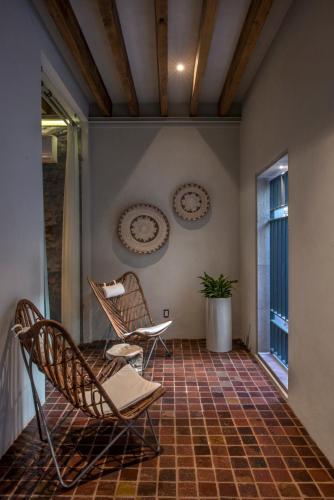 a porch with two chairs and a window at Casa Cien Hilos in San Miguel de Allende