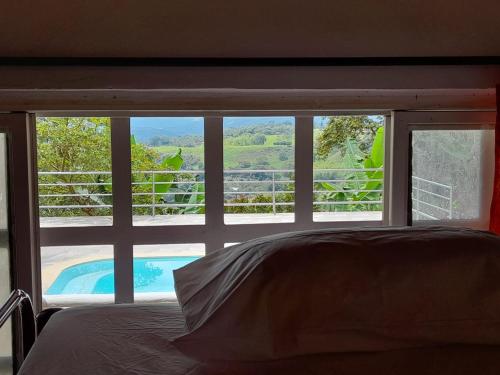 a bedroom with a view of a pool through a window at FINCA CORENAS in La Cumbre