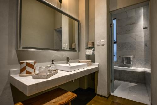 a bathroom with a sink and a mirror at Casa Cien Hilos in San Miguel de Allende