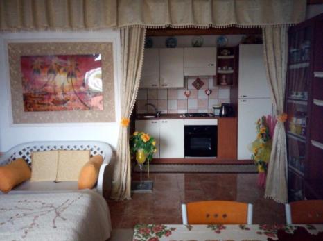 a living room with a couch and a kitchen at A casa di Sissy in Carrao