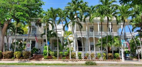 a white house with palm trees in front of it at The Palms Hotel in Key West