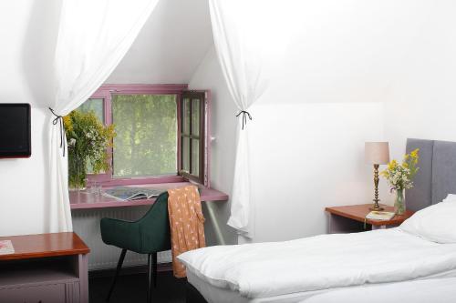 a bedroom with a bed and a desk and a window at Spichlerz na Krakowskiej in Kazimierz Dolny