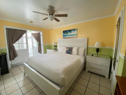 a bedroom with a bed and a ceiling fan at The Palms Hotel in Key West