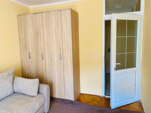 a living room with a couch and a closet at Sunny Parkside Apartment in Bar