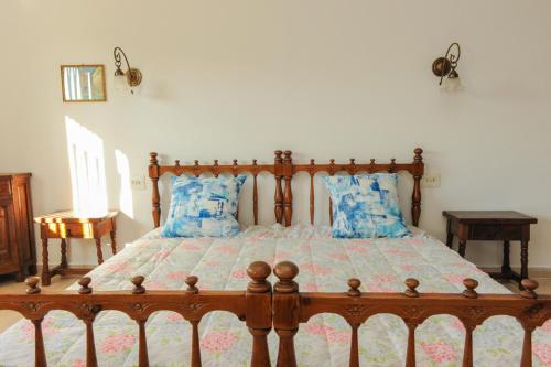 a bedroom with a wooden bed with blue pillows at Casa del Dorado Playa cambrils in Cambrils