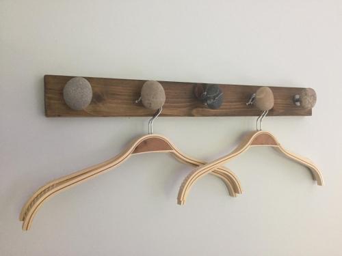 a wooden shelf with three hooks on a wall at Glenfalloch Beag Apartment, Torvaig in Portree