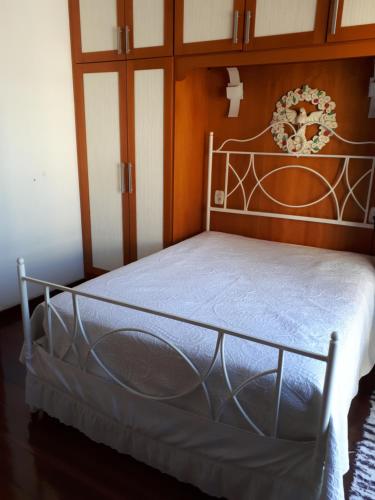 Schlafzimmer mit einem Bett mit einem Kopfteil aus Metall in der Unterkunft Hosts in Rio Homestay in Rio de Janeiro