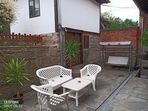 a patio with two chairs and a table and a grill at Guest House Strumena in Elena