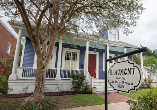 a blue house with a sign in front of it at The Beaumont House Natchez in Natchez