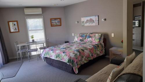 a bedroom with a bed and a table in it at Hidden Gem in Oaklands in Napier