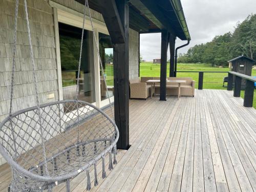 a swinging bench on a porch of a house at Spithami Seaside Wooden Chalet in Spithami