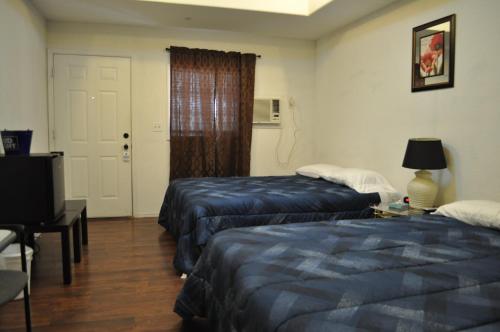 a hotel room with two beds and a television at K7 Bed and Breakfast in Pahrump
