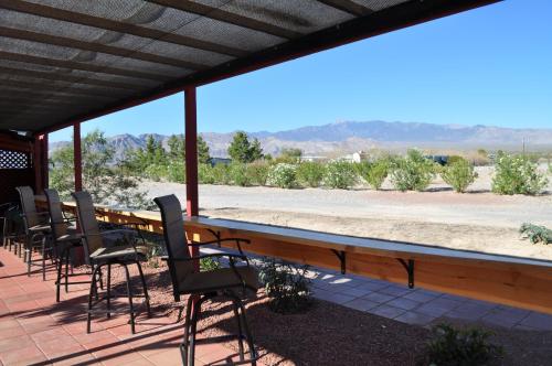 a patio area with chairs, tables, and benches at K7 Bed and Breakfast in Pahrump